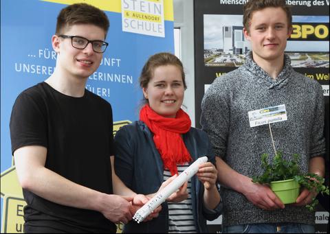 NASAの教育プログラムに初めて採用された、ドイツの学生によるプロジェクト エーディト・シュタイン・スクールに通う学生たち（左から、デイヴィット・ジェレイ氏、マリア・コッホ氏、ラファエル・シリング氏）。国際宇宙ステーションへ打ち　上げる植物「オオイタビ」を持って。